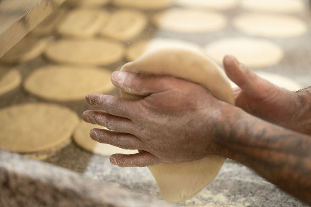 photo de mains qui façonnent des pâtes à pizza
